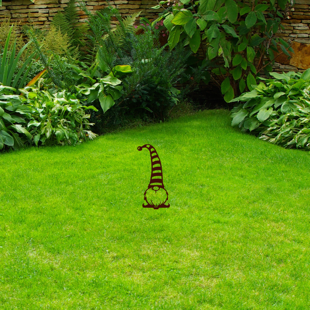 Gnome-shaped garden stake on a grassy lawn with plants in the background