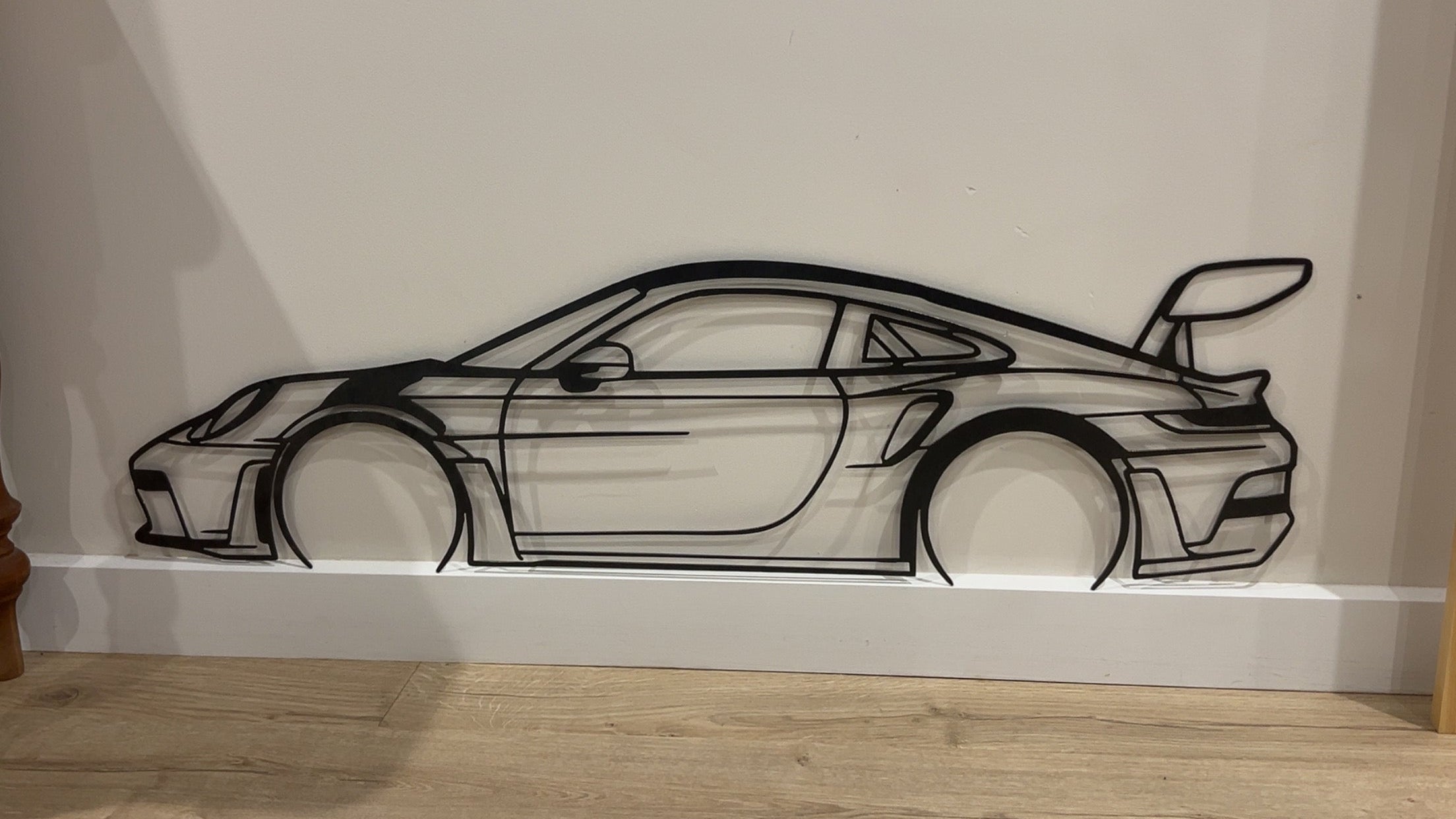 Decorative wall art of a car on a white wall.
