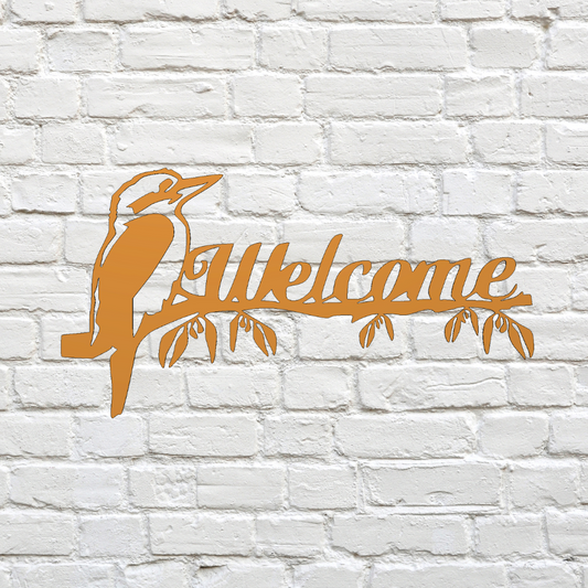 Decorative metal sign with a kookaburra design and 'Welcome' text on a white brick wall.